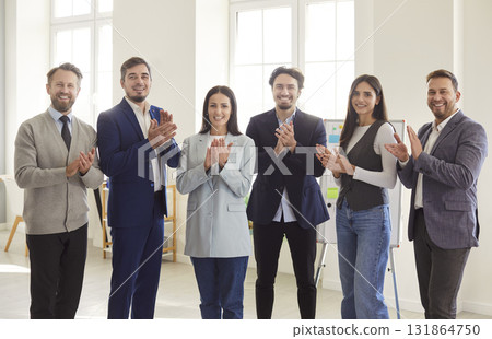 Group of happy confident business people looking at camera, smiling and applauding. Group of happy confident business people looking at camera, smiling and applauding. 131864750