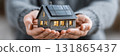 Hands Holding Model House with Solar Panels 131865437