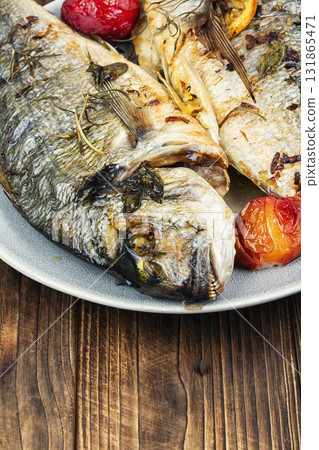 Grilled dorado fish with plums on wooden surface. Grilled dorado fish with plums on wooden surface. 131865471