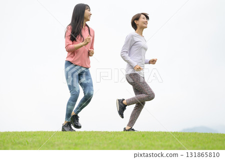 Two women running in the park 131865810