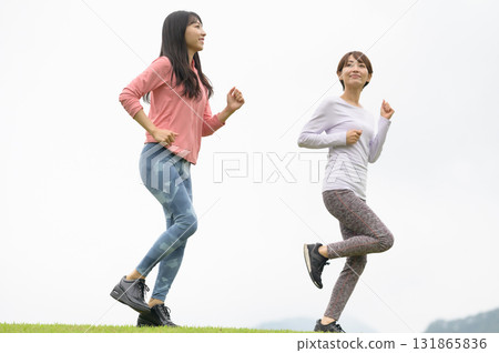 Two women running in the park 131865836