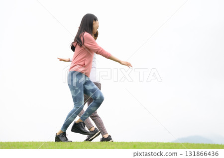 Two women high-fiving while running Two women high-fiving while running 131866436