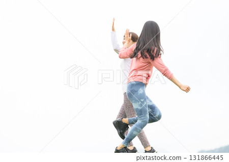 Two women high-fiving while running 131866445