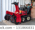 A red snowplow placed in a garage 131866831