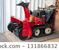 A red snowplow placed in a garage 131866832