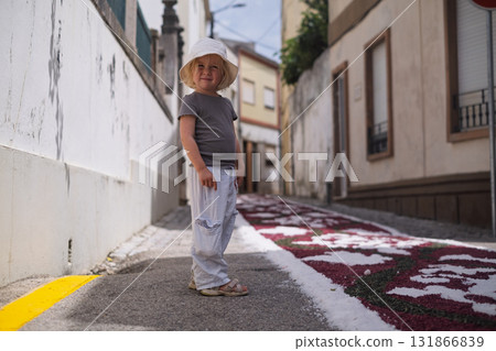 Girl looking at a traditional colorful carpet in Portugal during a Catholic festival 131866839
