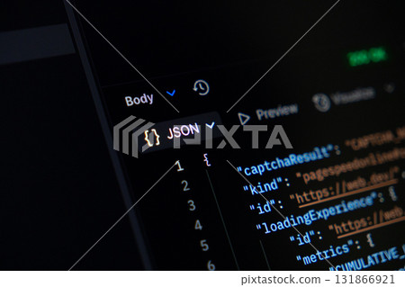 JSON programming code visible on a dark computer screen, illustrating data exchange protocols fundamental for modern web development and backend applications 131866921