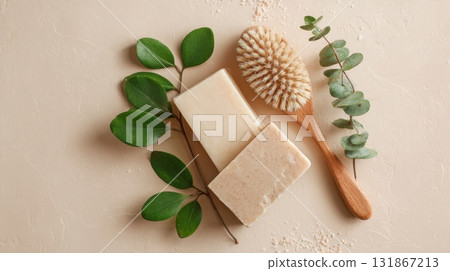 Eco spa flat lay with natural soap bars, green leaves, and wooden body brush on beige background Eco spa flat lay with natural soap bars, green leaves, and wooden body brush on beige background 131867213