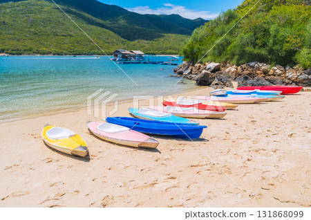 Kayaks on the sandy beach by sea in the blue lagoon in summer on vacation on a sunny day Kayaks on the sandy beach by sea in the blue lagoon in summer on vacation on a sunny day 131868099