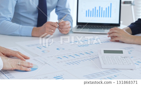 Accouters analyzing financial data using charts, graphs, and reports during an office meeting, collaborating on strategy. Business people concept Accouters analyzing financial data using charts, graphs, and reports during an office meeting, collaborating on strategy. Business people concept 131868371