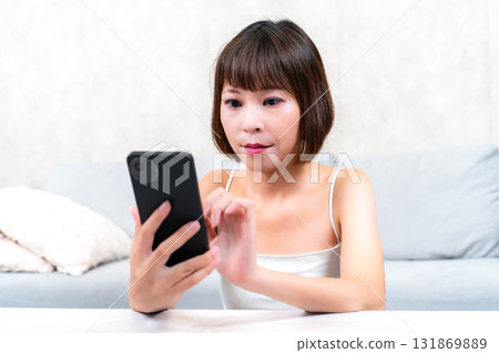 A young woman touching a smartphone 131869889