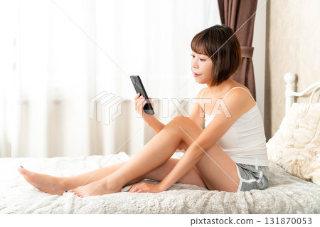 A young woman touching a smartphone 131870053