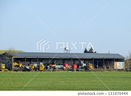 Tractors and other equipment under the awning in the garage. Tractors and other equipment under the awning in the garage. 131870444
