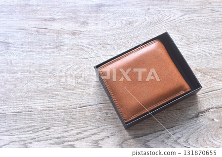 brown wallet in black hard paper box on wooden table 131870655