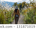 Back view of a woman walking along a path lined with Japanese silver grass in autumn 131871019