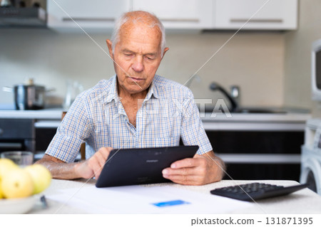 Elderly man using digital tablet to shop online from home 131871395