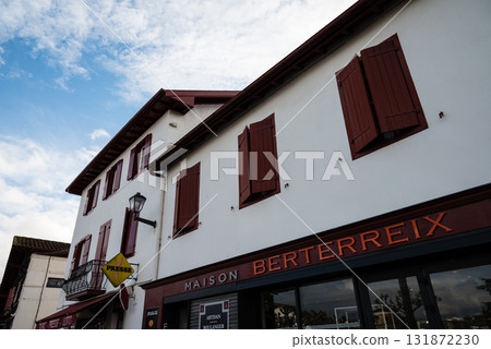 Red and white buildings decorated with chili peppers in Espelette, a village famous for its chili peppers in the French Basque Country 131872230