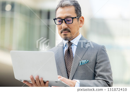 Senior men operating a computer Senior men operating a computer 131872410