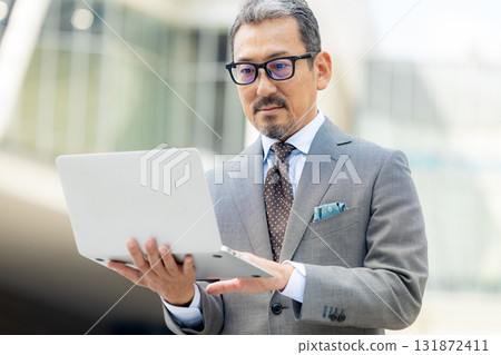 Senior men operating a computer Senior men operating a computer 131872411