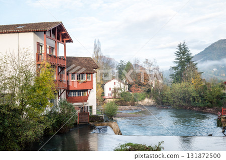 Historic buildings and trees along the river in the morning mist in Saint-Jean-Pied-de-Port, Basque Country, France Historic buildings and trees along the river in the morning mist in Saint-Jean-Pied-de-Port, Basque Country, France 131872500