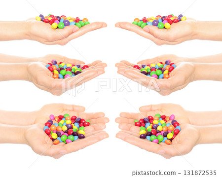 Set of hands holding colorful candies, isolated on transparent background Set of hands holding colorful candies, isolated on transparent background 131872535
