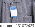 Visitor badge is attached to gray shirt, featuring collar and pocket. badge is prominently displayed, indicating temporary guest status 131872625