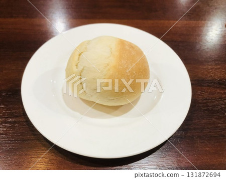 A small roll on a white plate A small roll on a white plate 131872694