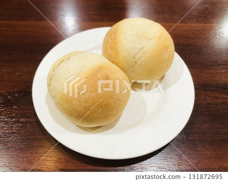 Two small rolls on a white plate 131872695