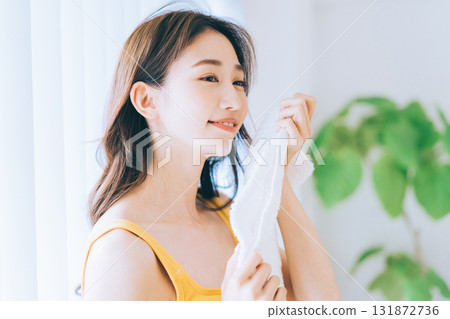 A woman wiping his face with a towel A woman wiping his face with a towel 131872736