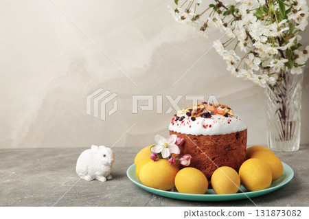 Traditional easter cakes with colorful sprinkles, with eggs, a bunny figurine, and spring flowers, creating a festive holiday scene 131873082