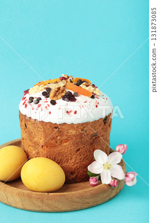 Traditional easter cakes with colorful sprinkles, with eggs and spring flowers on blue background. Traditional easter cakes with colorful sprinkles, with eggs and spring flowers on blue background. 131873085