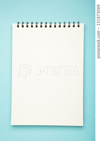 White spiral notebook mockup on blue background. Vertical photo White spiral notebook mockup on blue background. Vertical photo 131873089