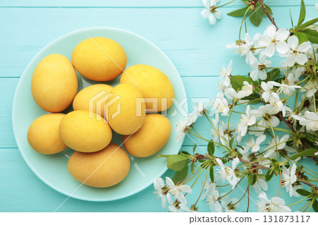 Easter eggs and spring flowers on blue background. Easter eggs and spring flowers on blue background. 131873117