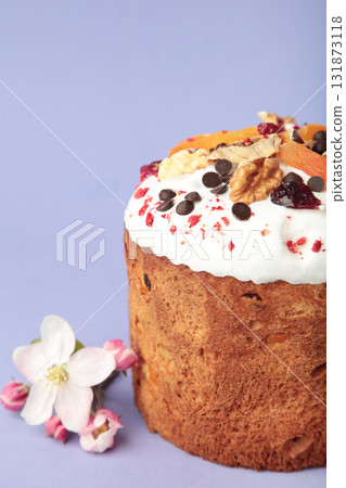 Traditional easter cakes with colorful sprinkles and spring flowers on purple background. Vertical photo Traditional easter cakes with colorful sprinkles and spring flowers on purple background. Vertical photo 131873118