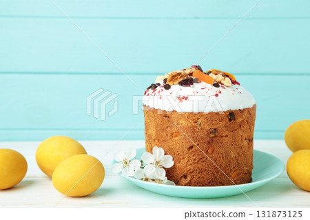 Traditional easter cakes with colorful sprinkles, with eggs, a bunny figurine, and spring flowers, creating a festive holiday scene 131873125