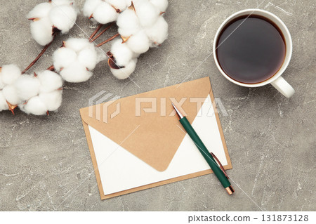 Composition with craft envelope and cotton branch on grey concrete background Composition with craft envelope and cotton branch on grey concrete background 131873128