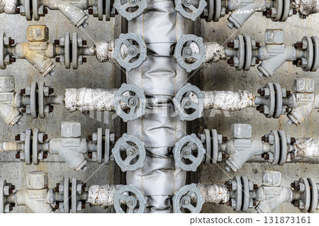 Row of valves are on a pipe 131873161