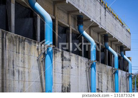 Blue pipe is attached to a building Blue pipe is attached to a building 131873324