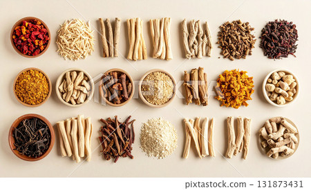 A neatly arranged flat lay of dried adaptogenic roots and herbs such as ashwagandha and rhodiola, displayed in small wooden bowls on a neutral background, symbolizing natural wellness and balance 131873431