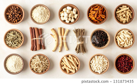 A neatly arranged flat lay of dried adaptogenic roots and herbs such as ashwagandha and rhodiola, displayed in small wooden bowls on a neutral background, symbolizing natural wellness and balance 131873435