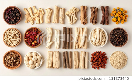 A neatly arranged flat lay of dried adaptogenic roots and herbs such as ashwagandha and rhodiola, displayed in small wooden bowls on a neutral background, symbolizing natural wellness and balance 131873440