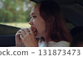 woman girl eating burger car, happy person, Girl eating burger in car, Young woman enjoys burger, Tasty lunch on road trip, Snack time in vehicle, Fast food break in car, Eating inside automobile 131873473