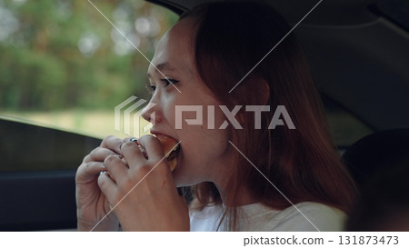 woman girl eating burger car, happy person, Girl eating burger in car, Young woman enjoys burger, Tasty lunch on road trip, Snack time in vehicle, Fast food break in car, Eating inside automobile woman girl eating burger car, happy person, Girl eating burger in car, Young woman enjoys burger, Tasty lunch on road trip, Snack time in vehicle, Fast food break in car, Eating inside automobile 131873473