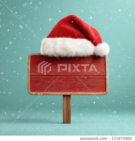 Wooden red sign on a stick with a Santa hat on top standing in snow on light blue green background with a candy cane pole. Christmas theme signboard decoration. Cheerful festive signpost banner. 131873800