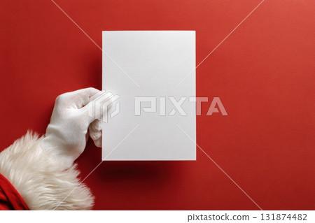 Santa Claus Hand Holding Blank Paper Sign Isolated On Red Background. Close Up. Christmas Gifts Buying. White Gloved Hand and Vertical Page Card MockUp Template. Advertisement gesture. Xmas List, Mail Santa Claus Hand Holding Blank Paper Sign Isolated On Red Background. Close Up. Christmas Gifts Buying. White Gloved Hand and Vertical Page Card MockUp Template. Advertisement gesture. Xmas List, Mail 131874482