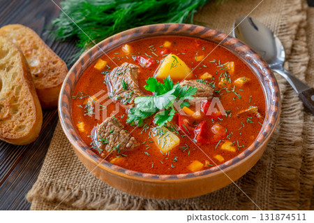 Traditional Bogracs stew garnished with parsley served with toasted bread beside 131874511