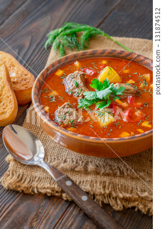 Traditional Bogracs stew garnished with parsley served with toasted bread beside 131874512