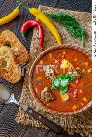 Rustic Bogracs stew topped with parsley served with toasted bread and chilies 131874513