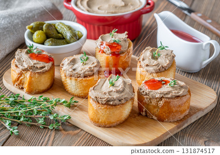 Turkey liver pate on toast with cornichons and cranberry sauce beside 131874517