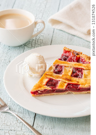 Cherry pie slice with melting ice cream and coffee on white plate Cherry pie slice with melting ice cream and coffee on white plate 131874526